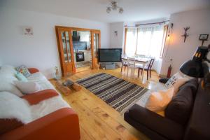a living room with two couches and a television at Aura's Guest House in Sadova
