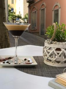 a martini glass sitting on a table next to a plant at Hotel Centrale in Olbia