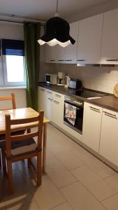 a kitchen with white cabinets and a table and a table and chair at Pension Altes Forstamt in Eberswalde