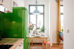 einen grünen Kühlschrank in einer Küche mit einem Tisch in der Unterkunft Enjoy Leipzig in Leipzig