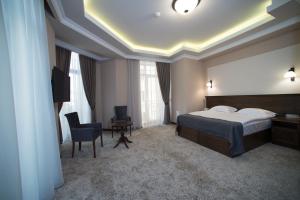 um quarto de hotel com uma cama, uma secretária e uma cadeira em Boulevard Hotel em Yerevan