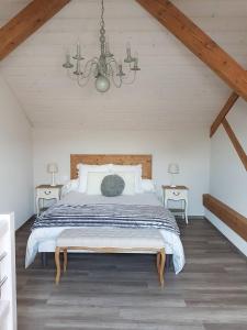 a bedroom with a large bed and a chandelier at L'Ecrin du Lac in Saint-Point-Lac