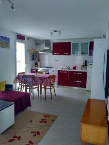 a kitchen and living room with a table and chairs at Apartman Nora in Hvar