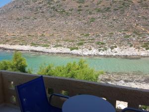 a balcony with blue chairs and a view of a river at Little Bay in Stavros