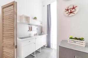 a white kitchen with a sink and a counter at Incentro in Gallipoli