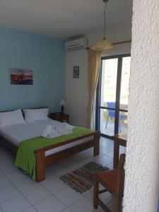 Schlafzimmer mit einem Bett und einer Glasschiebetür in der Unterkunft Little Bay in Stavros
