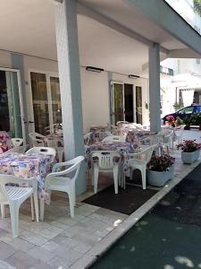 un gruppo di tavoli e sedie su un patio di Hotel Madrid a Riccione