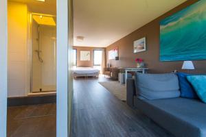 a living room with a couch and a bedroom at B&B Beach Inn in Scheveningen