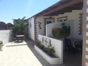a house with a patio with a table and chairs at Appartamento Vincenzina in Lampedusa
