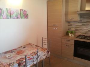 a small kitchen with a table and a table and chairs at Appartamento Vincenzina in Lampedusa