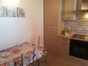 a kitchen with a table and a small kitchen with a stove at Appartamento Vincenzina in Lampedusa