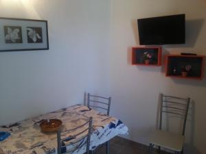 a dining room with a table and a tv on the wall at Appartamento Vincenzina in Lampedusa
