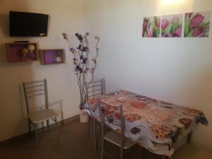 a dining room with a table and chairs and a tv at Appartamento Vincenzina in Lampedusa