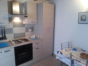 a kitchen with a stove top oven next to a table at Appartamento Vincenzina in Lampedusa
