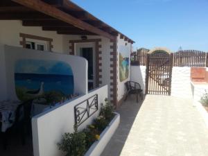 a house with a fence and a patio at Appartamento Vincenzina in Lampedusa