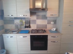 a small kitchen with a stove and a sink at Appartamento Vincenzina in Lampedusa