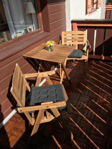 einen Holztisch und zwei Stühle auf einer Veranda in der Unterkunft Ferienwohnung Kogelblick Gosau in Gosau