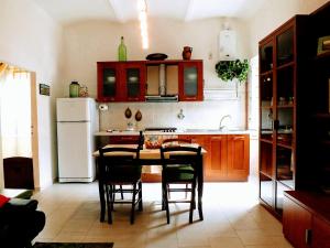 eine Küche mit einem Tisch und Stühlen sowie einem Kühlschrank in der Unterkunft Centralissimo nel cuore del borgo in Suvereto