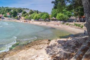 a beach with people swimming in the water at Apartment Stella in Murter
