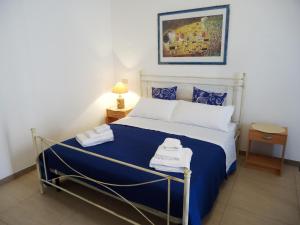 パチェーコにあるApartments Drago di Ferroのベッドルーム1室(青と白のシーツが備わるベッド1台付)
