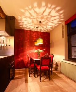 a dining room with a table and red walls at Maison Au Cheval Noir in Maastricht