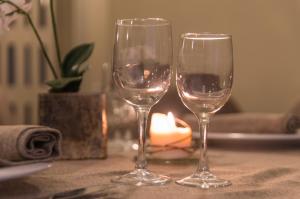 2 verres à vin assis sur une table avec une bougie dans l'établissement Hotel Ristorante Bologna, à San Piero in Bagno