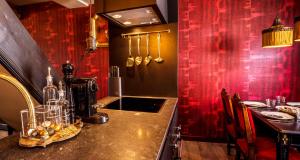 a kitchen with a counter and a red wall at Maison Au Cheval Noir in Maastricht +16 photos