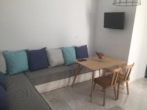 ein Wohnzimmer mit einem Sofa und einem Tisch in der Unterkunft Ansi Studios & Apartments in Almyrida