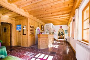 a kitchen with wooden walls and a ceiling with beams at Hotel Edelhof in Tarvisio