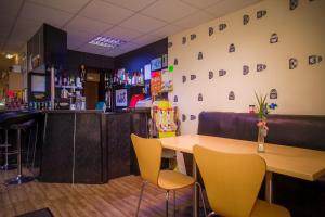 a bar with a wooden table and yellow chairs at The Penrhyn in Blackpool
