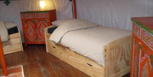 a bedroom with a wooden bed and a dresser at Yourte d'Aiguevives in Céré-la-Ronde