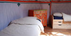 a bedroom with a tent with a bed and a dresser at Yourte d'Aiguevives in Céré-la-Ronde +9 photos