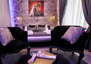 a living room with two chairs and a bed at Bourbon House in Naples