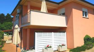 a house with a white fence and an umbrella at Apartments Simag in Banjole