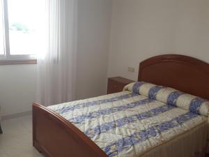 a bedroom with a bed with a blue and white quilt at Casa Artemia in Sanxenxo