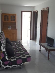 a living room with a couch and a television at Casa Artemia in Sanxenxo