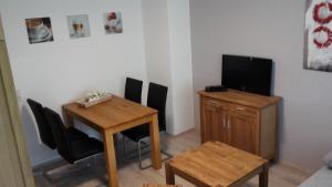 ヴィリンゲンにあるFerienwohnungen Langのテーブル、テレビ、テーブル、椅子が備わる客室です。