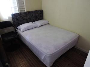 a bed with two pillows on it in a room at Casa temporada 2 quartos in São Thomé das Letras