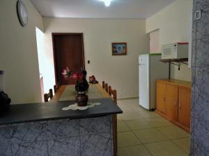 a kitchen with a table with a vase of flowers on a counter at Casa temporada 2 quartos in São Thomé das Letras