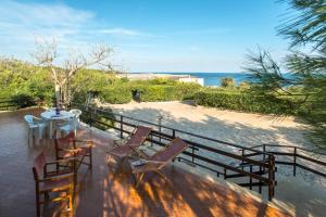 um pátio com uma mesa e cadeiras e a praia em la casa nell'acqua em Otranto