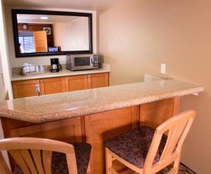 a kitchen with a counter with two chairs and a microwave at Holiday Inn Express Grand Canyon, an IHG Hotel in Tusayan