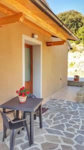 a patio with a table and chairs and a house at Sonnellino in Maremma in Massa Marittima