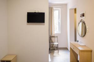 a room with a tv on the wall and a desk at LUX Hotel 5 mins walk from port of Piraeus and metro station in Piraeus +65 photos