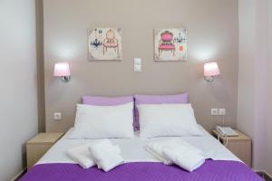sypialnia z purpurowym łóżkiem z 2 białymi poduszkami w obiekcie LUX Hotel w Pireusie