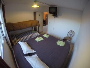 1 dormitorio pequeño con 1 cama y 1 silla en Alojamiento Goos en Puerto Pirámides