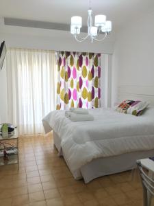 Un dormitorio con una cama grande y una lámpara de araña. en Barbara Suite Obelisco Best Location ig barbarasuites en Buenos Aires