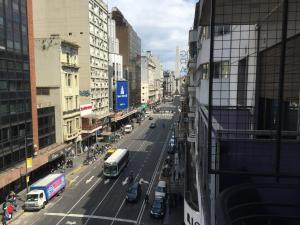 Vistas a una concurrida calle de la ciudad con coches y autobuses en Barbara Suite Obelisco Best Location ig barbarasuites en Buenos Aires