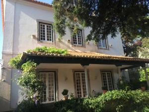 a white house with windows and plants on it at Villa Branca Jacinta in Sintra