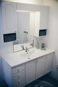 a white bathroom with a sink and a mirror at Dalhus - House with jacuzzi in Norddal +36 photos