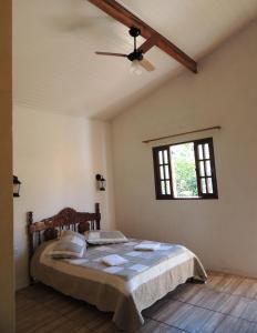 1 dormitorio con 1 cama y ventilador de techo en Pousada Fazenda São Luiz, en São Luís do Paraitinga